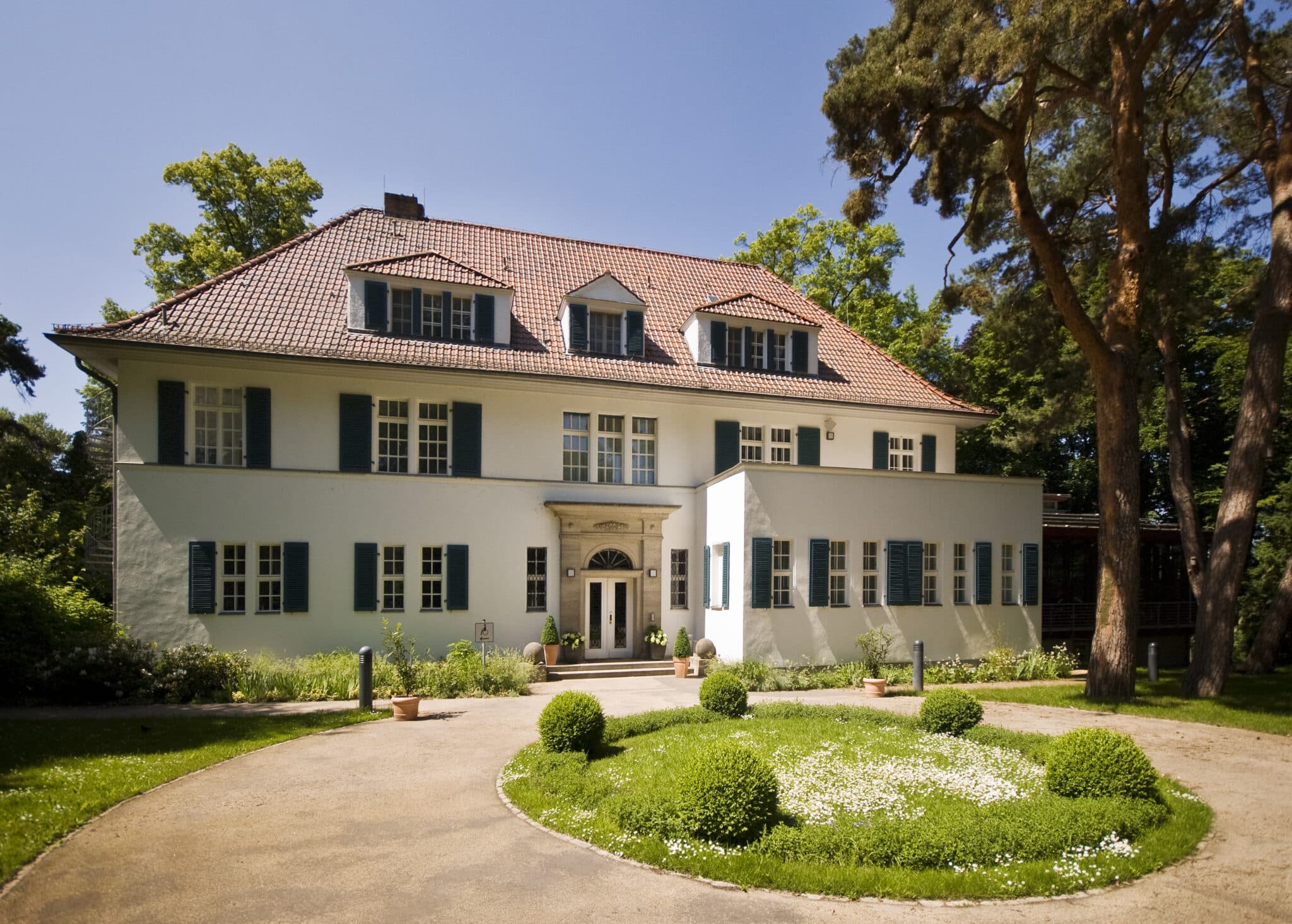 Evangelische Bildungsstätte auf Schwanenwerder mit grünem Garten und klassischer Architektur in Berlin.