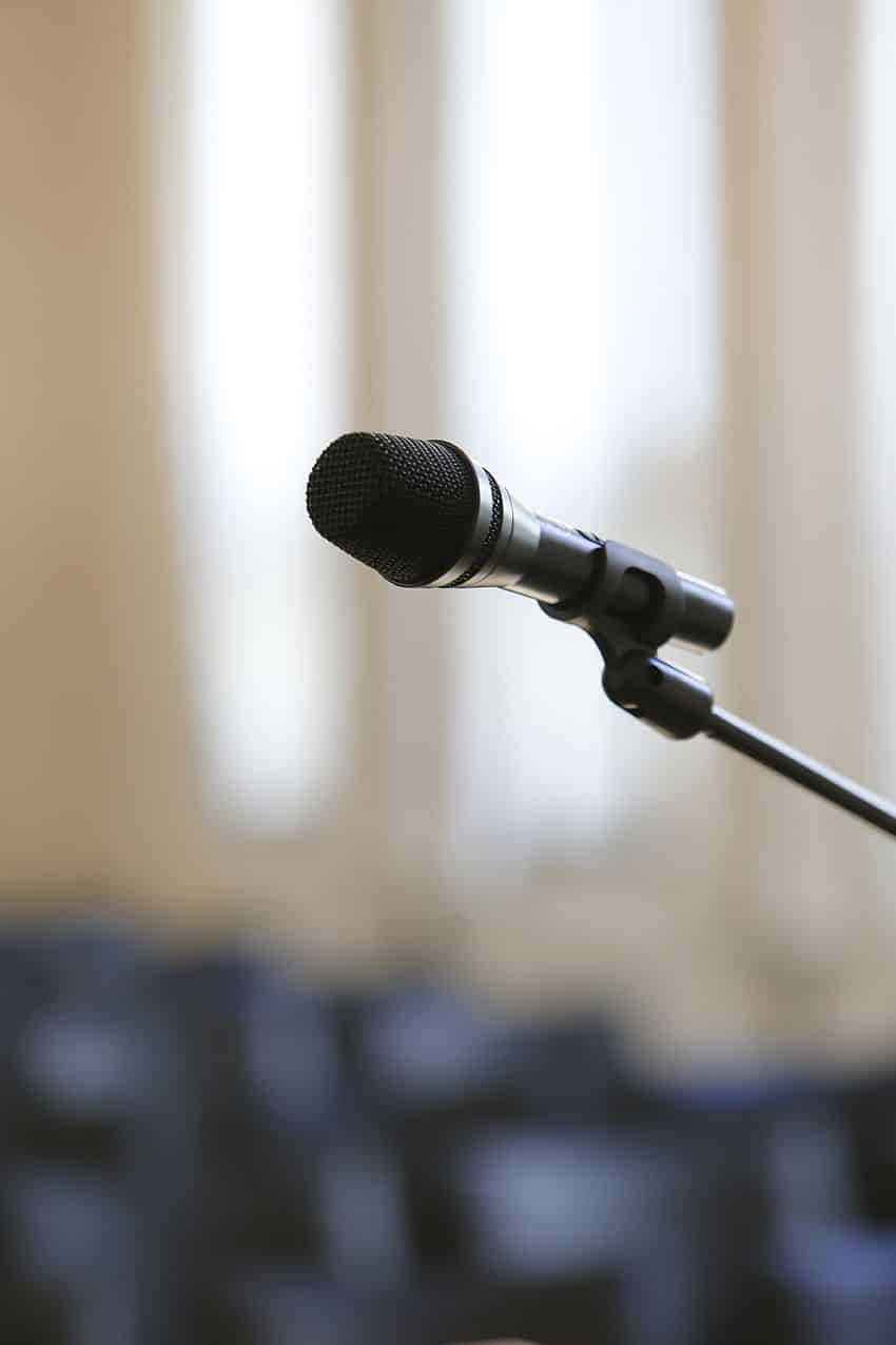 Mikrofon auf einem Stativ in einem Raum mit verschwommenem Hintergrund.