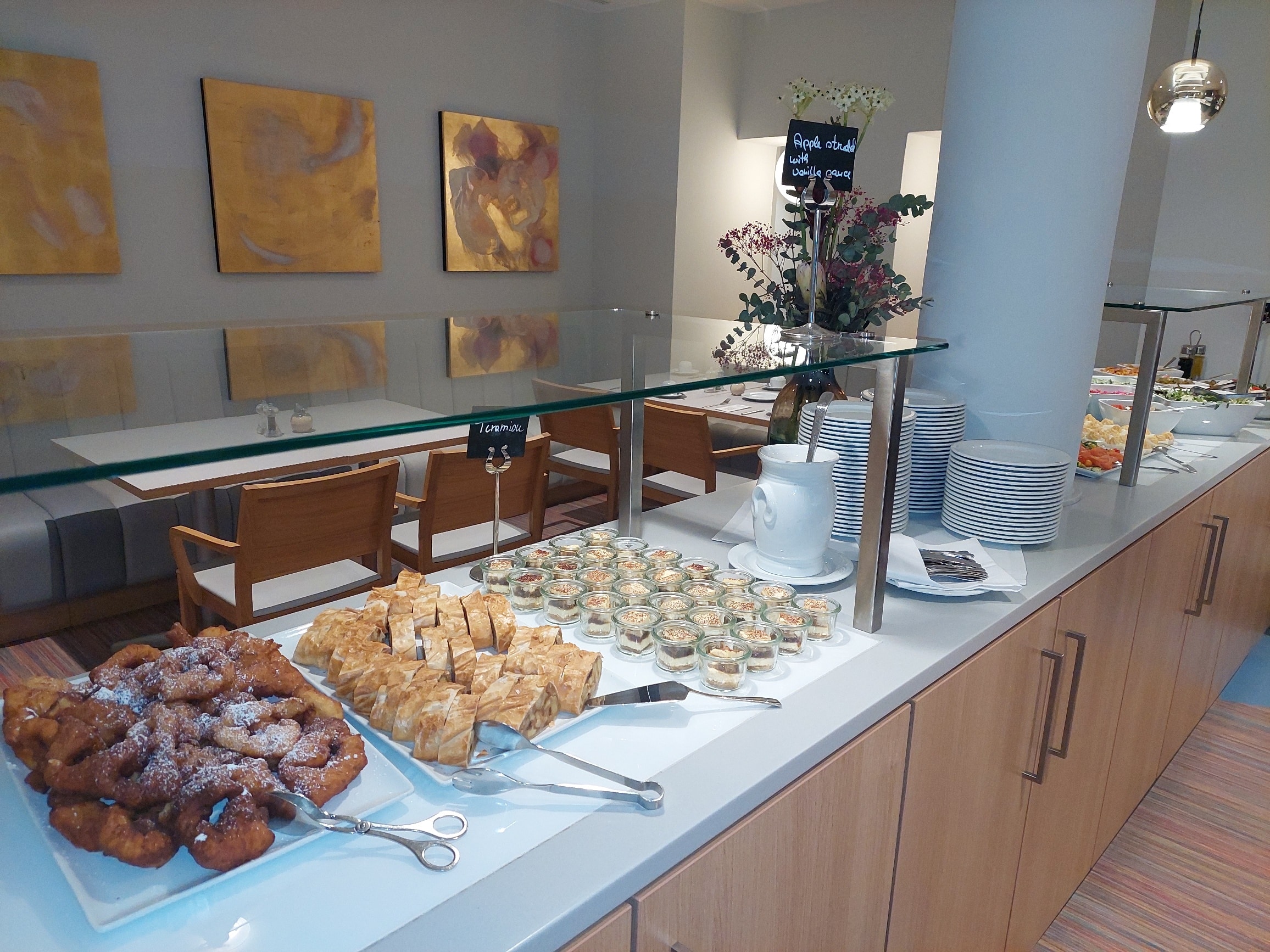 Ein Buffet mit einer Auswahl an Gebäck, Desserts und kleinen Snacks auf einem Tisch.